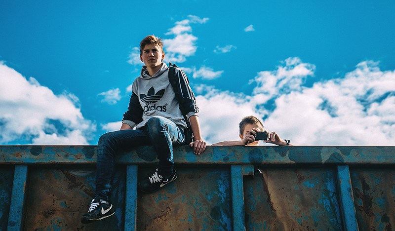 Two teenage boys sitting on a wall