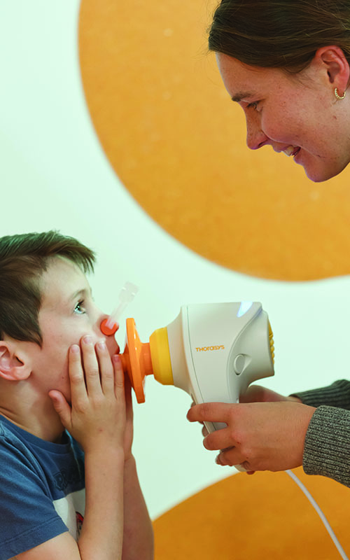 Research Assistant Tiffany Bradshaw helps seven year old Pierce Brazier undertake a lung function test